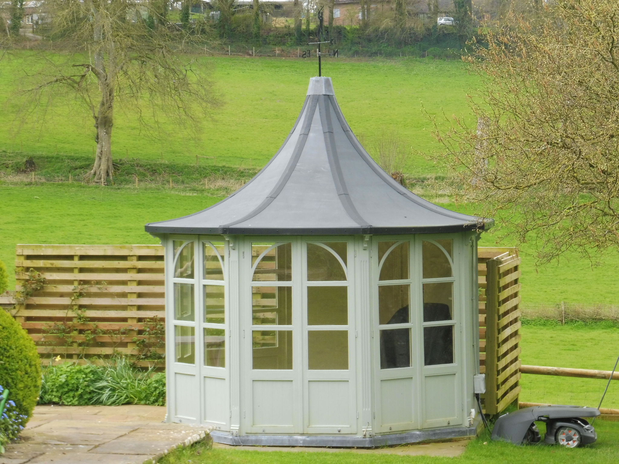 A pretty summer house with a traditional olive green with a pointed roof.